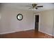 Open living room with hardwood floors, a clock on the wall, and a ceiling fan at 4143 E Maiden Rd, Maiden, NC 28650