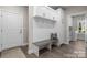 Hallway mudroom with a gray bench seat, coat hooks, overhead cabinets, and a white entry door at 4210 Holly Ne Cir, Conover, NC 28613