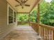 Covered back porch with a ceiling fan, ideal for outdoor lounging with wooded views at 4699 Cherrystone Rd, Lancaster, SC 29720