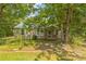 Charming single-story home featuring a metal roof and inviting front porch, nestled amongst mature shade trees at 4699 Cherrystone Rd, Lancaster, SC 29720