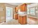 Kitchen featuring wooden cabinets, laminate counters, and neutral tiled flooring at 4699 Cherrystone Rd, Lancaster, SC 29720