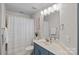 Well-lit bathroom featuring a sleek vanity and a shower with patterned shower curtain at 4708 S Hill View Dr, Charlotte, NC 28210
