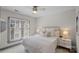 Bright bedroom featuring a ceiling fan, bedside tables with lamps, and natural light through the windows at 4708 S Hill View Dr, Charlotte, NC 28210