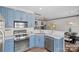 Open kitchen showcasing stainless steel appliances and blue cabinets with eat in dining area at 4708 S Hill View Dr, Charlotte, NC 28210