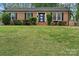 Traditional brick home with well-manicured lawn, black shutters, and updated front door at 4932 Delivau Dr, Charlotte, NC 28215