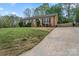 Charming brick home with a well-maintained lawn, long driveway, and traditional architectural details at 4932 Delivau Dr, Charlotte, NC 28215