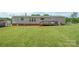Home exterior with a well-maintained lawn, small deck and a storage shed, offering functionality and outdoor appeal at 6785 Knotty Wood Ln, Vale, NC 28168