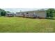 Home exterior with a well-maintained lawn, small deck and a storage shed, offering functionality and outdoor appeal at 6785 Knotty Wood Ln, Vale, NC 28168