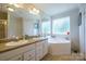 Relaxing bathroom features a soaking tub, dual sinks, and bright windows at 6785 Knotty Wood Ln, Vale, NC 28168