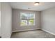Well-lit bedroom showcases a window offering neighborhood views and neutral carpeting at 6907 Hunts Mesa Dr, Fort Mill, SC 29707