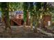 Inviting backyard with a multi-tiered deck, brick house exterior, mature trees and charming string lights at 9334 New Towne Dr, Matthews, NC 28105