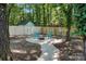 Cozy backyard with a fire pit and seating area, surrounded by trees and a privacy fence at 9334 New Towne Dr, Matthews, NC 28105