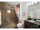Bathroom featuring tiled shower, pebble flooring, modern vanity, and fixtures at 9334 New Towne Dr, Matthews, NC 28105