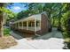 Side view of a charming home with a welcoming porch, brick accents, and a well-kept lawn at 9334 New Towne Dr, Matthews, NC 28105