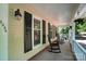 Inviting front porch with classic rocking chairs, decorative flower baskets, and black window shutters at 9334 New Towne Dr, Matthews, NC 28105