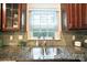 Kitchen featuring stainless steel sink, granite countertop and backsplash, and wood cabinets at 9334 New Towne Dr, Matthews, NC 28105