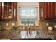 Close-up view of a stainless steel kitchen sink with a window view and tiled backsplash at 9334 New Towne Dr, Matthews, NC 28105
