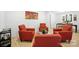 A modern living room with red chairs, hardwood floors, and bright natural lighting at 9334 New Towne Dr, Matthews, NC 28105