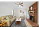 Cozy living room with a brick fireplace, neutral sofa, and hardwood flooring for a welcoming atmosphere at 9334 New Towne Dr, Matthews, NC 28105