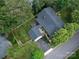 Aerial view of a home with lush greenery, a gray roof, a patio with outdoor seating and a paved driveway at 112 8Th Nw Ave, Hickory, NC 28601