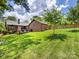 Brick home with manicured lawn, mature trees, and a wooden fence and deck in the backyard at 112 8Th Nw Ave, Hickory, NC 28601
