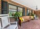 Inviting front porch featuring comfortable seating, brick accents, decorative plants, and mosaic tile flooring at 112 8Th Nw Ave, Hickory, NC 28601