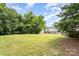 A large, lush backyard with ample green space and a view of the home's exterior at 1216 Catawba Run, Lowell, NC 28098