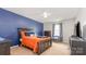 A cozy bedroom featuring a comfortable bed, blue accent wall, and stylish decor at 1216 Catawba Run, Lowell, NC 28098