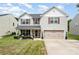 Charming two-story home featuring a well-manicured lawn and inviting front porch at 1216 Catawba Run, Lowell, NC 28098