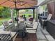 Outdoor patio area featuring a dining set, an umbrella, and comfortable lounge seating at 1216 Catawba Run, Lowell, NC 28098