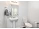Clean powder room features a pedestal sink, a modern toilet, and neutral wall color at 1216 Catawba Run, Lowell, NC 28098