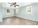 Spacious bedroom with three windows, light green walls, ceiling fan, and hardwood flooring at 127 Bristol Rd, Statesville, NC 28677