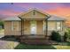 Inviting home with a charming front porch, yellow siding, and well-maintained landscaping at 127 Bristol Rd, Statesville, NC 28677