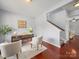 Bright home office featuring modern desk, stylish chairs, and hardwood floors with staircase in the background at 1307 Farm Branch Sw Dr, Concord, NC 28027