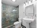 Bathroom features a glass-enclosed shower with decorative tile, and a pedestal sink with traditional-style fixtures at 17811 Half Moon Ln # E, Cornelius, NC 28031