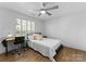Bright bedroom features a ceiling fan, natural light from a window, and a dedicated workspace with a desk at 17811 Half Moon Ln # E, Cornelius, NC 28031