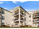 Beautiful three-story condo with multiple balconies and classic white siding on a manicured lawn at 17811 Half Moon Ln # E, Cornelius, NC 28031