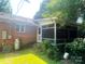 Back of home featuring a screened in porch, brick exterior, and grassy yard at 1834 Sharonwood Ln, Rock Hill, SC 29732