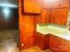 A kitchen with wooden cabinets and paneling, featuring a green countertop and tiled floor at 1834 Sharonwood Ln, Rock Hill, SC 29732