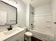 Well-lit bathroom with a single sink vanity, a shower and tub combo, and dark hardware at 211 Surrey Oak Ln, Charlotte, NC 28216
