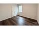 An empty bedroom with a closet, a window with blinds, and dark wood floors at 211 Surrey Oak Ln, Charlotte, NC 28216