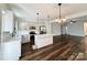 An open concept kitchen boasts stainless steel appliances, modern white cabinetry, and a center island at 211 Surrey Oak Ln, Charlotte, NC 28216