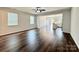 Spacious living room featuring wood flooring, plentiful natural light, and modern ceiling fan at 211 Surrey Oak Ln, Charlotte, NC 28216