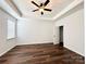 Spacious main bedroom with wood-look flooring, tray ceiling, and bright natural light at 211 Surrey Oak Ln, Charlotte, NC 28216