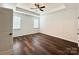 Bright main bedroom with tray ceiling, wood-look flooring, and ample natural light at 211 Surrey Oak Ln, Charlotte, NC 28216