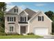 Charming two-story brick home with stone accents, black shutters, and an attached two-car garage at 3026 Tramore Dr, Harrisburg, NC 28075