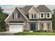 Charming two-story home featuring stone accents, a two-car garage, and a welcoming front entrance at 3073 Tramore Dr, Harrisburg, NC 28075