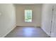 Bright bedroom with light laminate flooring, neutral walls, and a window at 405 S South St, Gastonia, NC 28052