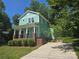 Inviting two-story home with a quaint front porch and a long concrete driveway at 405 S South St, Gastonia, NC 28052