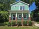 Charming two-story home features a welcoming front porch and vibrant green siding at 405 S South St, Gastonia, NC 28052